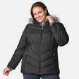 A woman is smiling and posing with one hand touching the hood while wearing the Free Country Women’s Plus Size Unstoppable II Poly Air Touch Jacket in black. This jacket features lightweight eco-friendly REPREVE insulation and a faux fur-trimmed hood, offering both warmth and style.