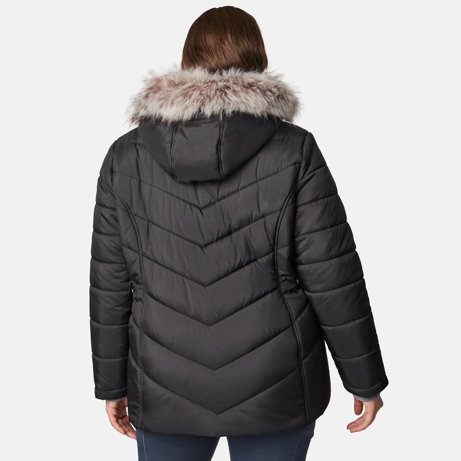 A person is shown from the back against a plain white background, wearing the Free Country Women’s Plus Size Unstoppable II Poly Air Touch Jacket in black, featuring a fur-lined hood and eco-friendly REPREVE fill.