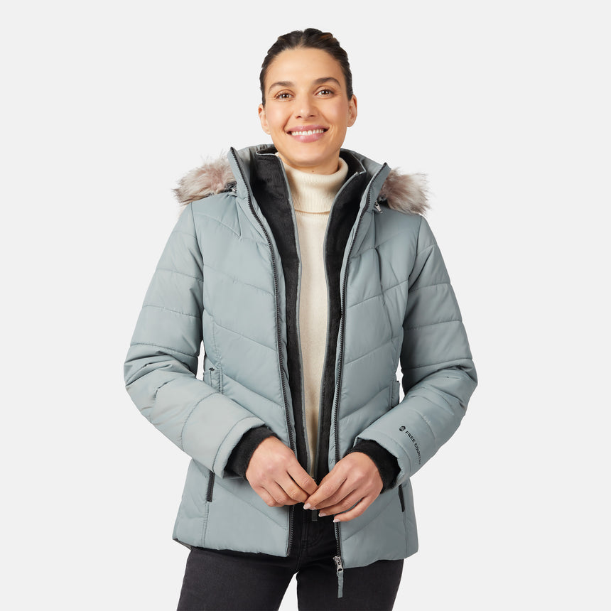 [Olga is 5'9" wearing size S.] Model wearing green quilted jacket with faux fur hood and attached bib — layered warmth and stylish silhouette for winter outings