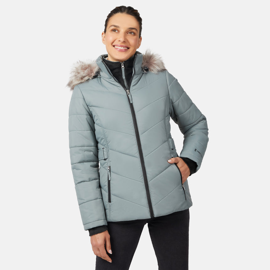 [Olga is 5'9" wearing size S.] Model wearing green quilted jacket with faux fur hood and attached bib — layered warmth and stylish silhouette for winter outings