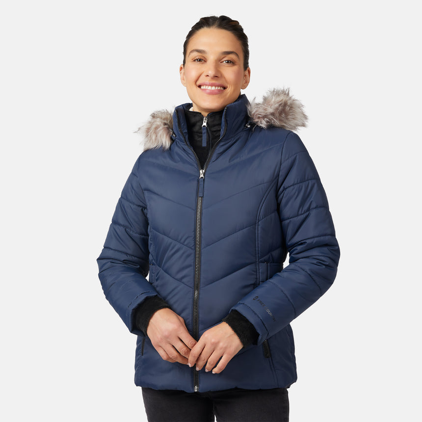 [Olga is 5'9" wearing size S.] Model wearing blue quilted jacket with faux fur hood and attached bib — layered warmth and stylish silhouette for winter outings