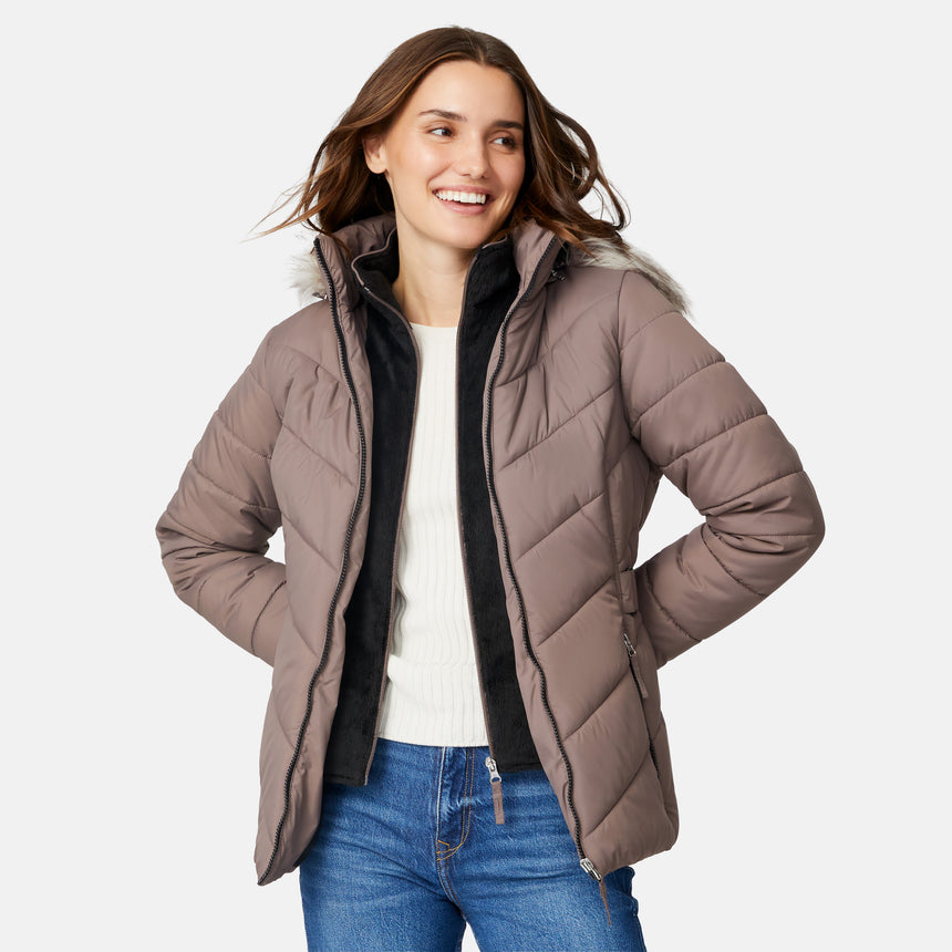 [Jessica is 5'9.5" wearing size S.] Model wearing brown quilted jacket with faux fur hood and attached bib — layered warmth and stylish silhouette for winter outings