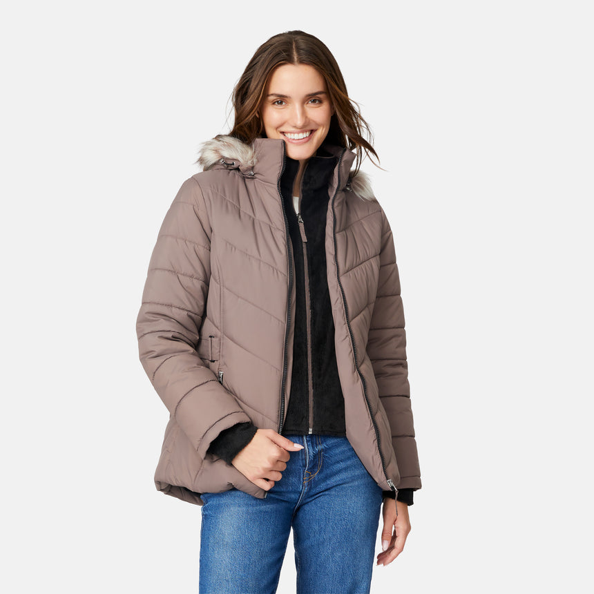 [Jessica is 5'9.5" wearing size S.] Model wearing brown quilted jacket with faux fur hood and attached bib — layered warmth and stylish silhouette for winter outings