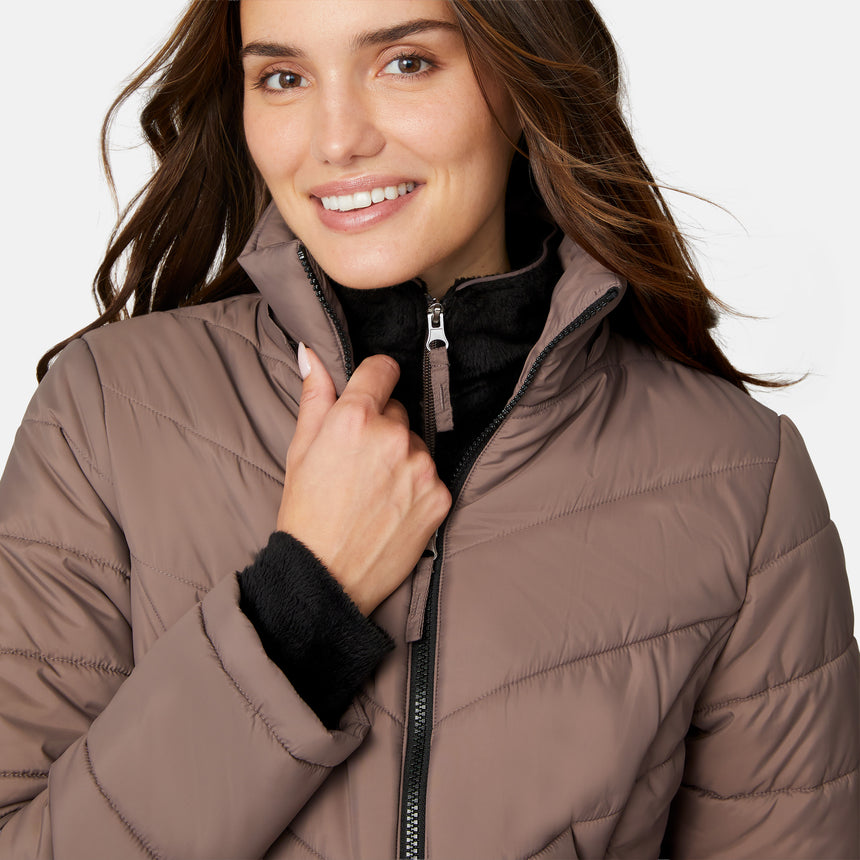 [Jessica is 5'9.5" wearing size S.] Model wearing brown quilted jacket with faux fur hood and attached bib — layered warmth and stylish silhouette for winter outings