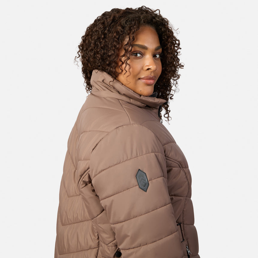 [Model is wearing size 1X] A woman with curly brown hair wearing a taupe-brown puffer jacket, shown from a side-back angle against a light gray studio background.