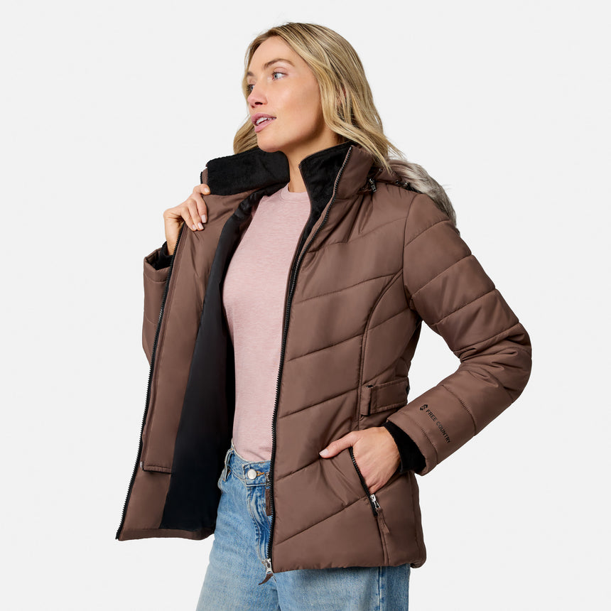 [Model is wearing size S.] A woman wearing a brown quilted puffer jacket with a black faux-fur collar, styled with a pink top and blue jeans against a light gray background.