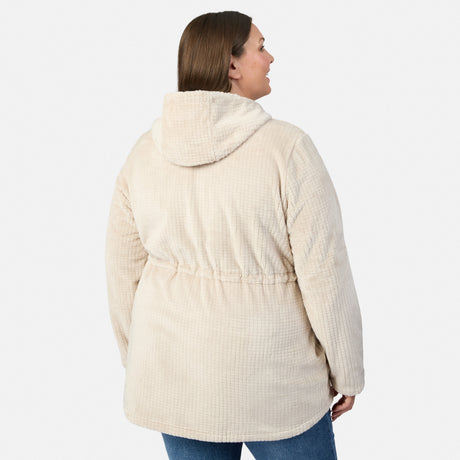 A woman models the Free Country Women’s Plus Size Grid Butter Pile® Anorak Jacket in light beige with blue jeans, standing with her back to the camera against a white background, highlighting its cozy fleece style.