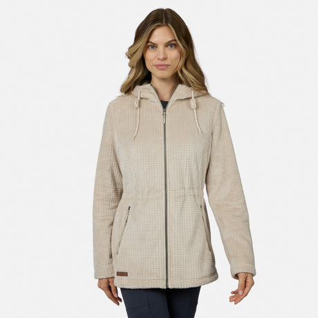 A woman with long, wavy hair wears the Free Country Women’s Grid Butter Pile® Anorak Jacket in light beige, featuring drawstrings, standing against a plain white background.