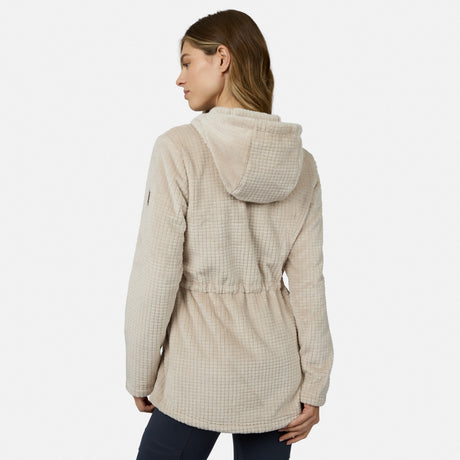 A woman with light brown hair models the Free Country Women’s Grid Butter Pile® Anorak Jacket in beige with dark pants, standing with her back to the camera against a plain white background.
