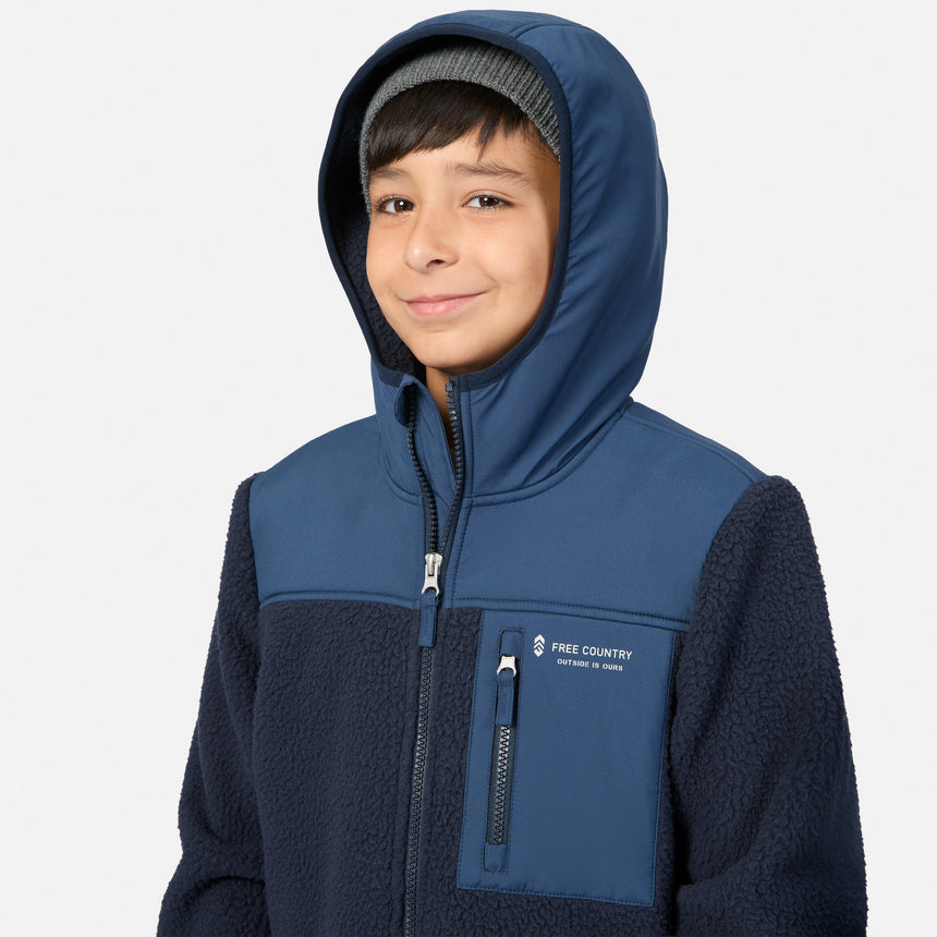 A child wearing a navy blue hooded fleece jacket with a zippered front and a chest pocket, photographed against a light gray studio background.