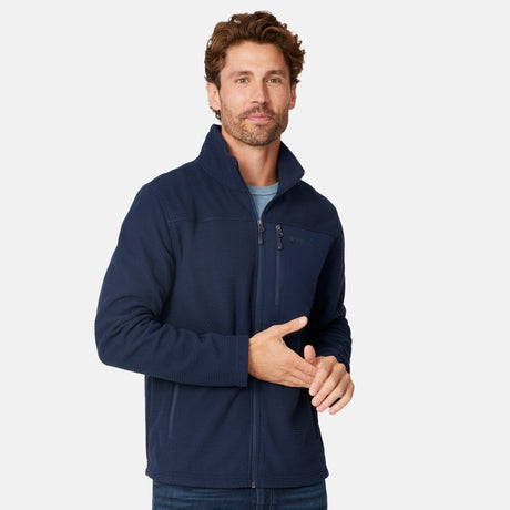 [Matt is 6'2" wearing size M.] Man wearing Free Country Men's Calabaza II Brick Fleece Jacket in navy with a zipper chest pocket, convertible collar, smiling looking forward, light grey background.