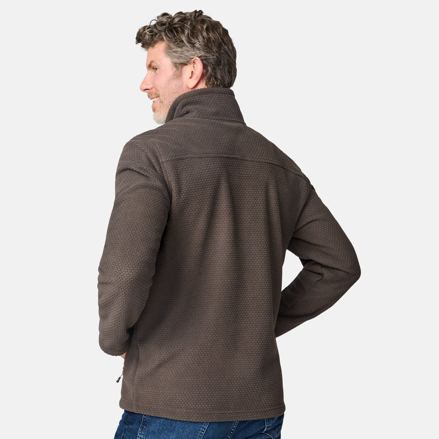 [Kolby is 6'2" wearing size M.] Men’s Free Country brown textured full-zip jacket with high collar and zippered chest pocket in contrast fabric—featuring a streamlined silhouette for cool-weather utility. Paired with blue jeans for a classic, casual outdoor look.