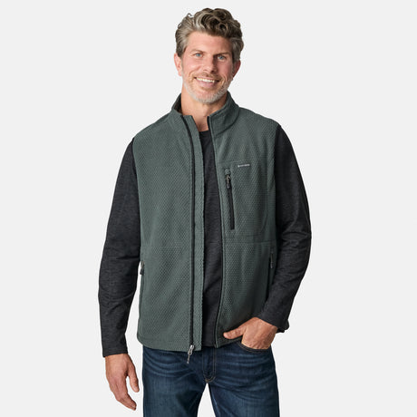 [Kolby is 6'2" wearing size M.] Men’s Free Country green zip-front vest with textured brick pattern and zippered chest pocket—layered over a dark grey long-sleeve shirt and blue jeans. Styled for a laid-back, outdoor-ready look against a clean white background.