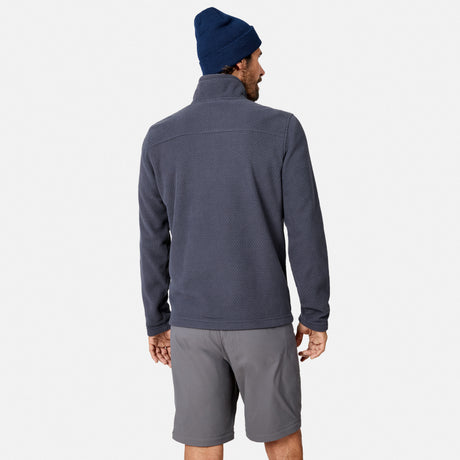 A man in a navy beanie, gray shorts, and the Free Country Men’s Calabaza II Brick Fleece Jacket stands facing away, highlighting the back of this versatile layering piece against a plain white background.