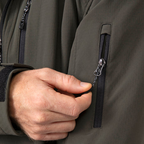 [Vince is 6'1" wearing a size Medium.] Man wearing Free Country Men's Odyssey II Flex Super Softshell® Jacket in dark green with a full front zipper opening, adjustable cuff openings, and wind and water resistant stretch performance fabric, light grey background. Perfect men’s jacket for fall weather.