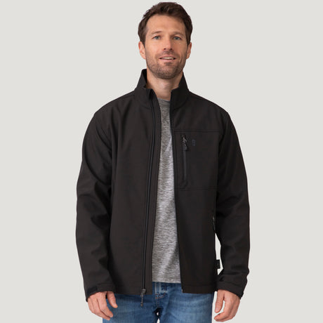 Man in black Hanson II Super Softshell Jacket with zipper down and visible front pockets over a gray shirt.