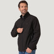 A man wearing a black Men’s Stretch Super Softshell® Jacket, a water-resistant, four-way stretch softshell with a zipper chest pocket and mock neck.