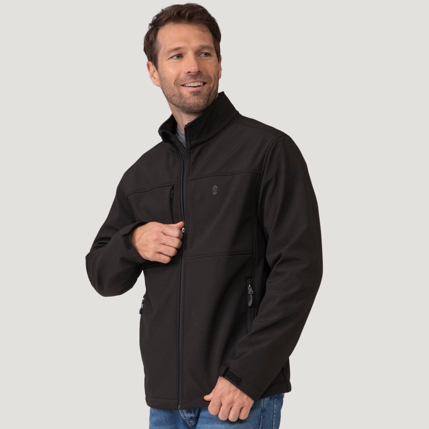 A man wearing a black Men’s Stretch Super Softshell® Jacket, a water-resistant, four-way stretch softshell with a zipper chest pocket and mock neck.
