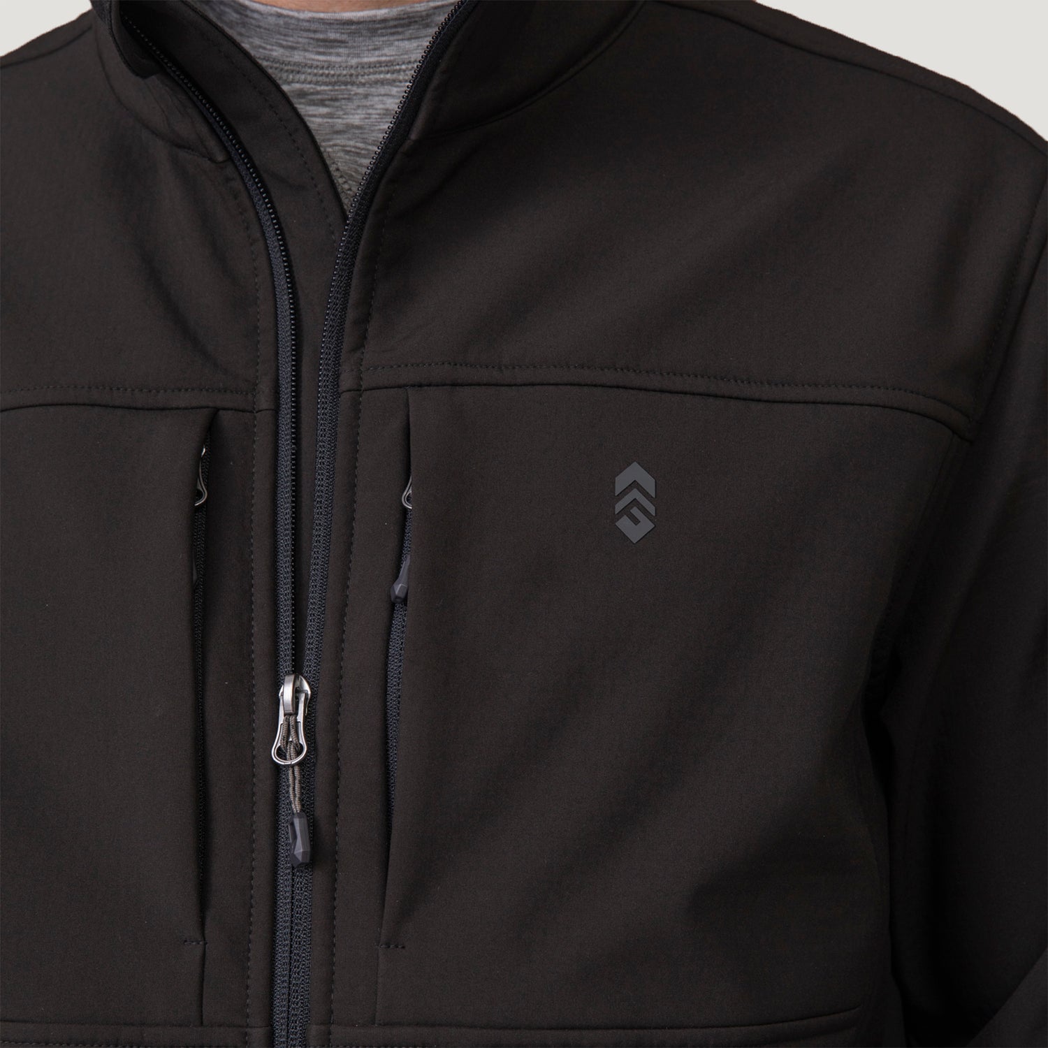 Close-up of a black, water-resistant Clearance Men’s Stretch Super Softshell® Jacket featuring a zipper, two vertical chest pockets, and a logo on the upper left.