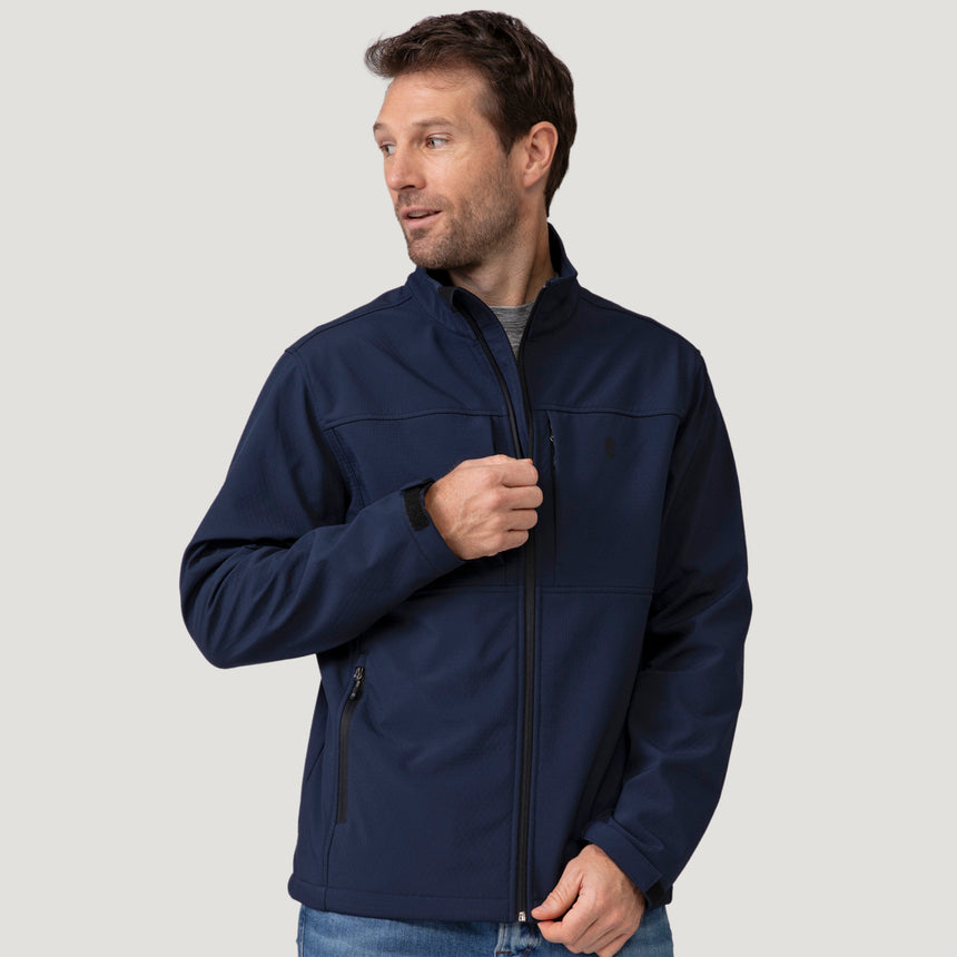 A man wearing a navy Men’s Stretch Super Softshell® Jacket featuring a water-resistant, four-way stretch fabric, a zippered front, and a chest pocket.