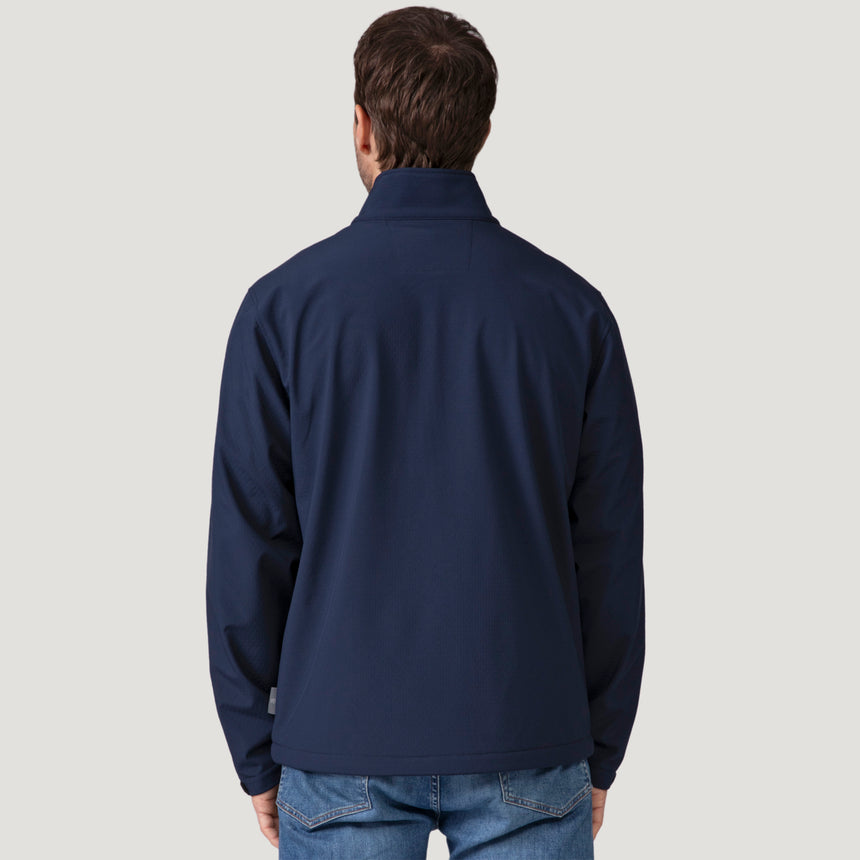 Back view of a person wearing a navy blue Men’s Stretch Super Softshell® Jacket and blue jeans.