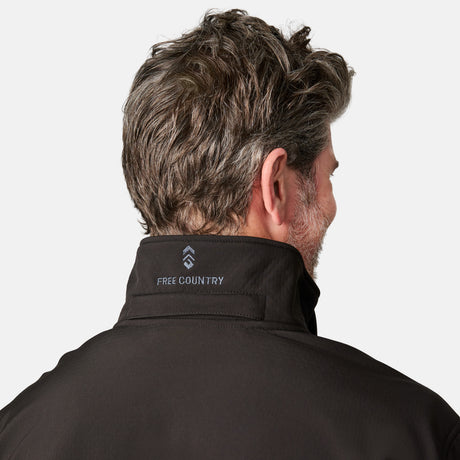 [Kolby is 6'2" wearing size M.] Man wearing Free Country Men's Odyssey II Flex Super Softshell® Jacket in black with a full front zipper opening, adjustable cuff openings, and wind and water resistant stretch performance fabric, light grey background. Perfect men’s jacket for fall weather.