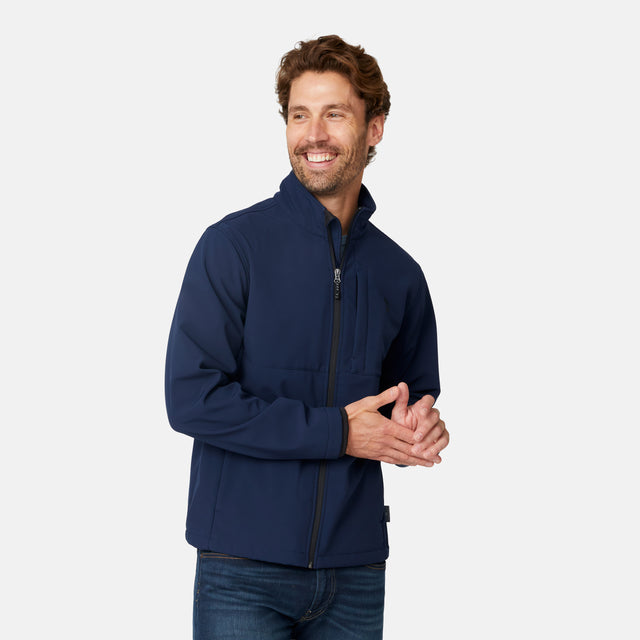 [Matt is 6'2" wearing size M.] Men’s Free Country navy zip-front softshell jacket with high stand collar and minimalistic design, worn over a light blue shirt and paired with blue jeans—delivering a clean, everyday look with subtle utility and transitional weather appeal.