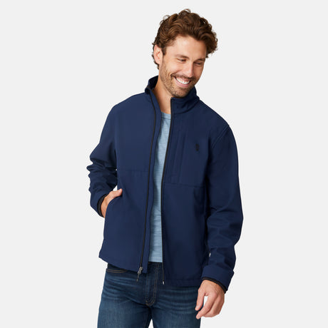 [Matt is 6'2" wearing size M.] Men’s Free Country navy zip-front softshell jacket with high stand collar and minimalistic design, worn over a light blue shirt and paired with blue jeans—delivering a clean, everyday look with subtle utility and transitional weather appeal.