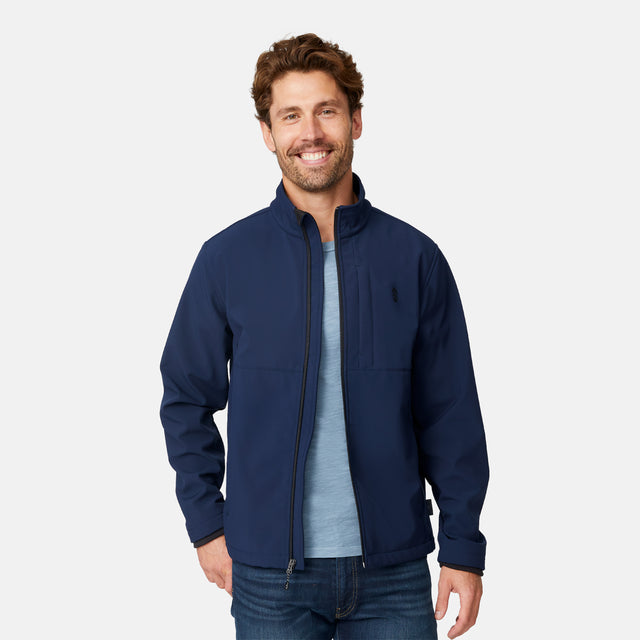 [Matt is 6'2" wearing size M.] Men’s Free Country navy zip-front softshell jacket with high stand collar and minimalistic design, worn over a light blue shirt and paired with blue jeans—delivering a clean, everyday look with subtle utility and transitional weather appeal.