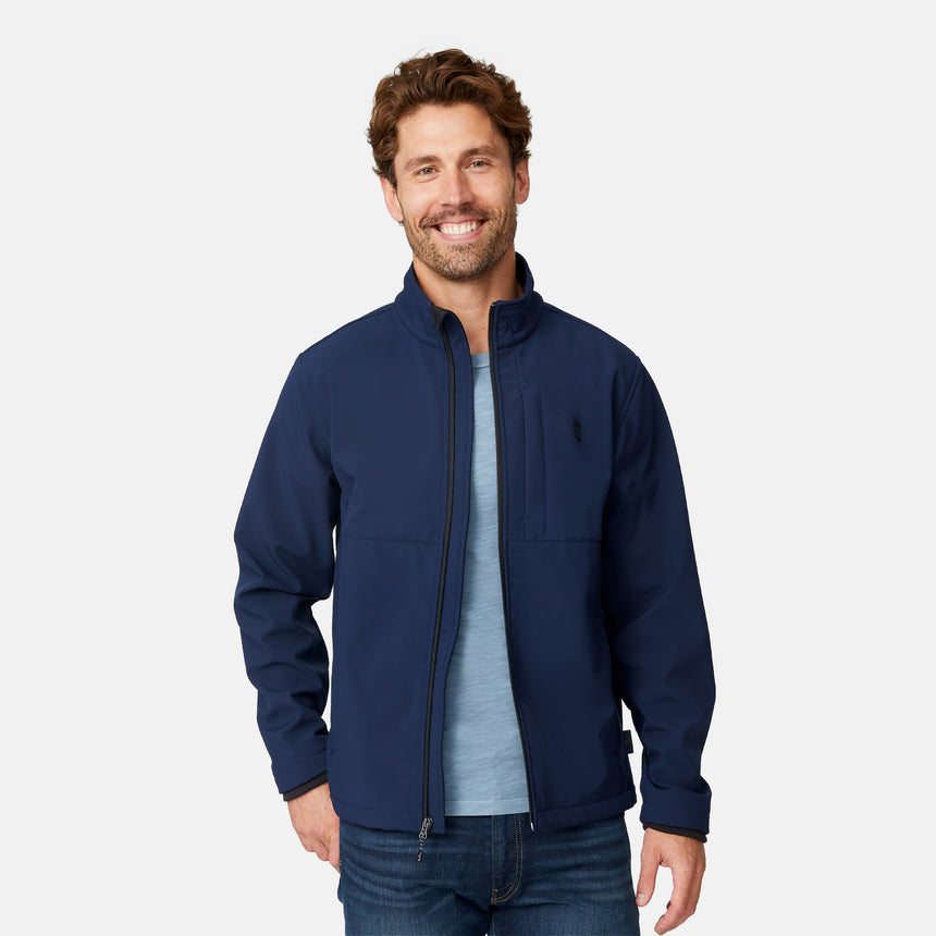 [Matt is 6'2" wearing size M.] Men’s Free Country navy zip-front softshell jacket with high stand collar and minimalistic design, worn over a light blue shirt and paired with blue jeans—delivering a clean, everyday look with subtle utility and transitional weather appeal.