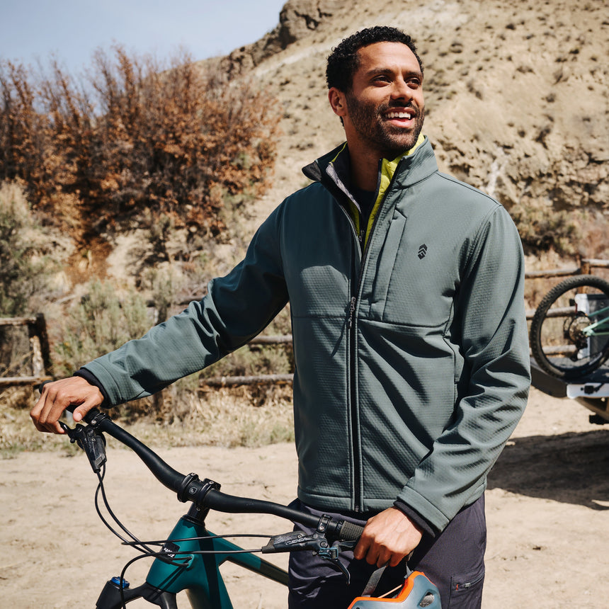 Man holding a bicycle in a desert-like setting