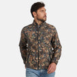 [Model is wearing size M.] A man wearing a camouflage-patterned lightweight jacket with a full-zip front and stand-up collar, paired with blue jeans, photographed against a plain light gray studio background.