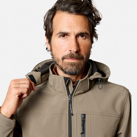 [Model is wearing size M.] A man wearing a light brown softshell hooded jacket, shown from the chest up against a light gray studio background. He is adjusting the collar with his right hand.
