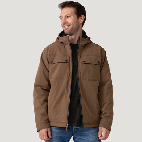 [Vince is 6’1” wearing size M.] Men’s Free Country brown hooded jacket with front zip closure and dual button-flap chest pockets. Worn over a charcoal tee and paired with blue jeans for a laid-back, utilitarian look that blends classic outerwear with everyday versatility.