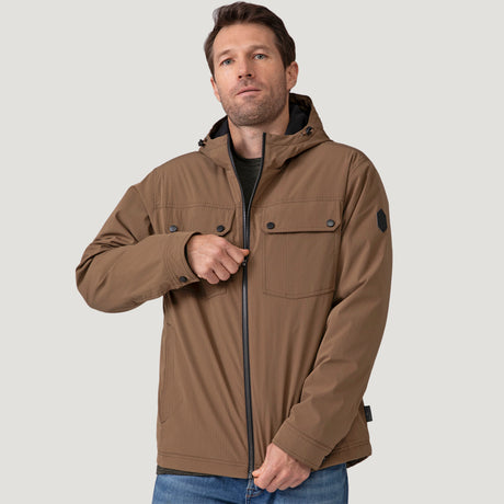 [Vince is 6’1” wearing size M.] Men’s Free Country brown hooded jacket with front zip closure and dual button-flap chest pockets. Worn over a charcoal tee and paired with blue jeans for a laid-back, utilitarian look that blends classic outerwear with everyday versatility.