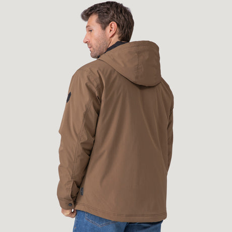 [Vince is 6’1” wearing size M.] Men’s Free Country brown hooded jacket with front zip closure and dual button-flap chest pockets. Worn over a charcoal tee and paired with blue jeans for a laid-back, utilitarian look that blends classic outerwear with everyday versatility.