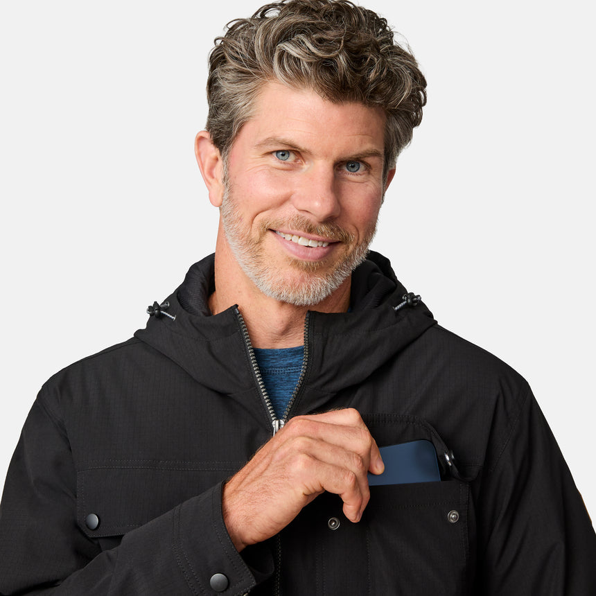 [Kolby is 6'2" wearing size M.] Men’s Free Country black hooded jacket with full-zip front, dual flap chest pockets, and button cuffs—featuring a clean silhouette and utility styling. Paired with brown pants for a rugged, cold-weather look that blends trail-ready function with everyday wearability.
