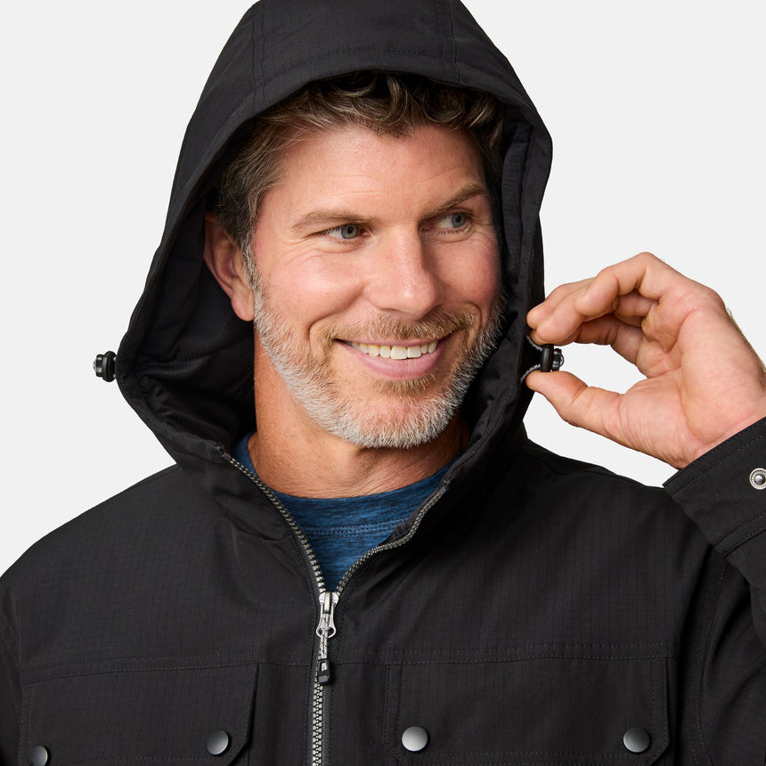 [Kolby is 6'2" wearing size M.] Men’s Free Country black hooded jacket with full-zip front, dual flap chest pockets, and button cuffs—featuring a clean silhouette and utility styling. Paired with brown pants for a rugged, cold-weather look that blends trail-ready function with everyday wearability.