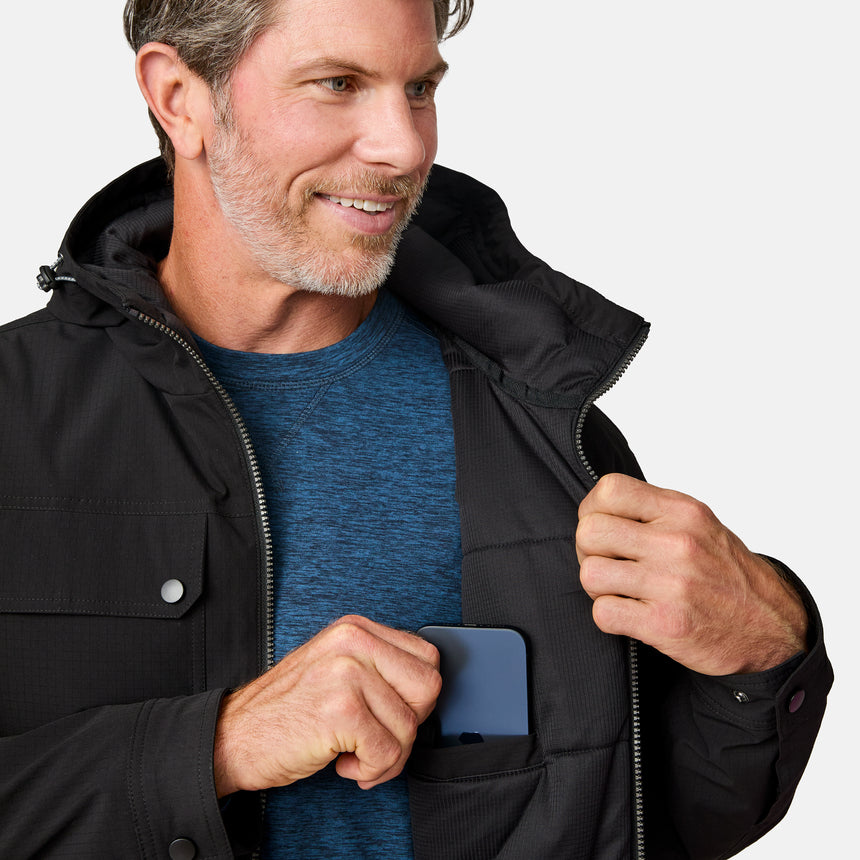 [Kolby is 6'2" wearing size M.] Men’s Free Country black hooded jacket with full-zip front, dual flap chest pockets, and button cuffs—featuring a clean silhouette and utility styling. Paired with brown pants for a rugged, cold-weather look that blends trail-ready function with everyday wearability.
