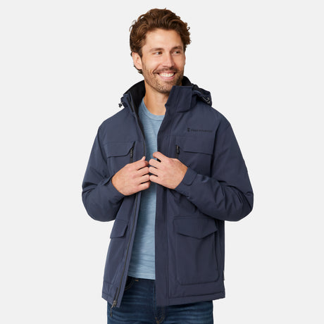 [Model is wearing size M.] A man wearing a navy blue hooded jacket over a light blue t-shirt and jeans, standing against a light gray studio background.