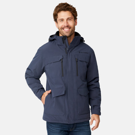 [Model is wearing size M.] A man wearing a navy blue hooded jacket with multiple zippered pockets, standing against a light gray studio background.