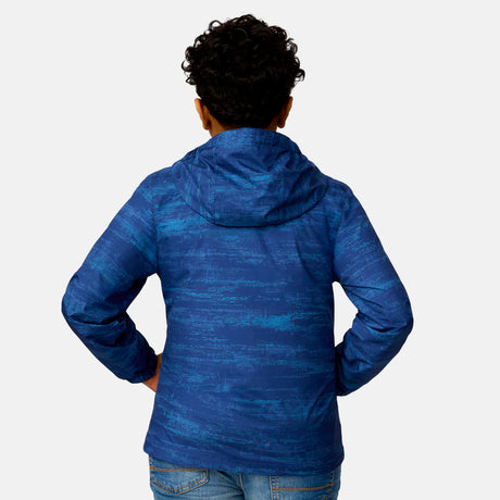[Model is wearing a size Medium.] Boy wearing the Free Country Boys' Easy Hiking Windshear Jacket in Trail Patterns, size M, featuring lightweight wind and water resistant fabric and an attached hood, paired with  blue jeans #color_ trail-patterns
