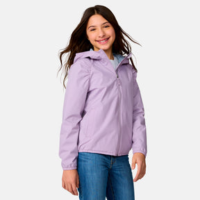 A smiling girl with long brown hair wears the Clearance Girls' High Stretch Windshear Jacket in light purple and blue jeans, standing against a plain light gray background.