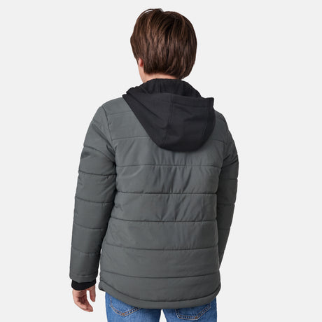 [River is wearing size M.] Model wearing a Free Country dark grey quilted hooded jacket featuring flap chest pockets, side hand pockets, and a partial front zip closure, paired with light innerwear and blue jeans—styled for casual outdoor comfort.