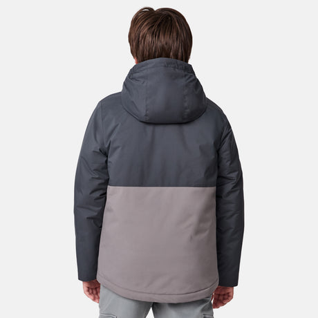 [River is wearing size M] Model in a two-tone Free Country system jacket featuring a dark gray upper shell and lighter gray lower body; complete with zip-out fleece liner, side-entry pockets, and an adjustable hood—styled with tonal gray pants for streamlined, cold-weather versatility.