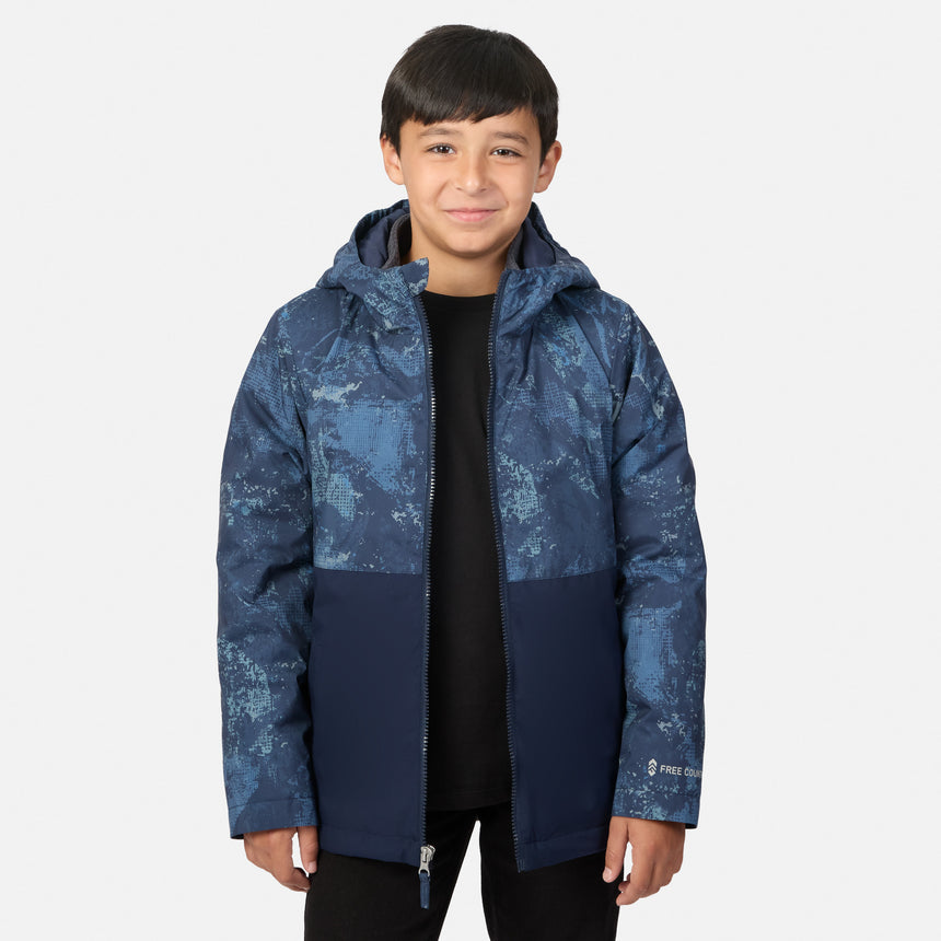 A boy wearing a Boys’ High Stretch 3-in-1 Systems Jacket in navy blue with a blue patterned top section over a black shirt.