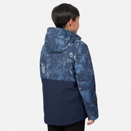 A boy seen from behind wearing a Boys’ High Stretch 3-in-1 Systems Jacket featuring a blue camo-print top and solid navy bottom.