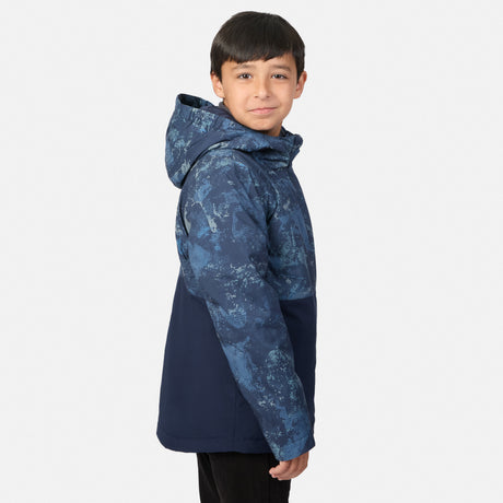 A boy wearing a navy blue Boys’ High Stretch 3-in-1 Systems Jacket with a blue patterned hood and upper chest.