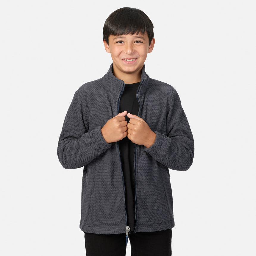 A smiling boy wearing a gray Boys’ High Stretch 3-in-1 Systems Jacket over a black t-shirt.