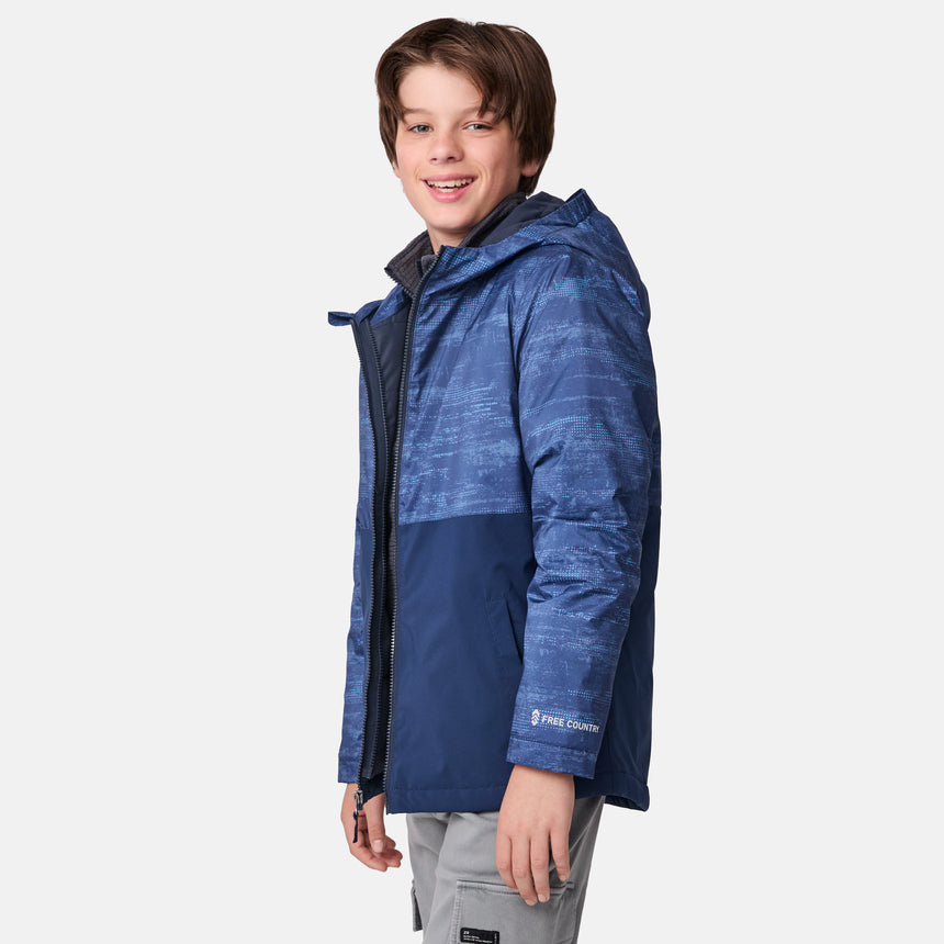 [River is wearing size M]Model in a two-tone blue Free Country 3-in-1 system jacket featuring zip-out fleece lining, rugged shoulder textures, and a smooth shell exterior; styled with a light base layer for adaptable, cold-weather comfort.
